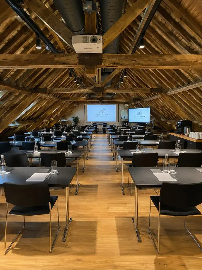 Seminar room beneath exposed timber beams, set up for DFDS